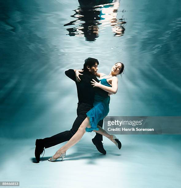 young couple under water dancing - tango dancers stock-fotos und bilder
