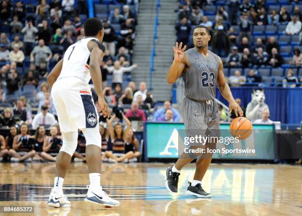 Monmouth Hawks Guard Austin Tilghman calls a play during the game while UConn Huskies Guard Christian Vital defends during the game between the UConn...