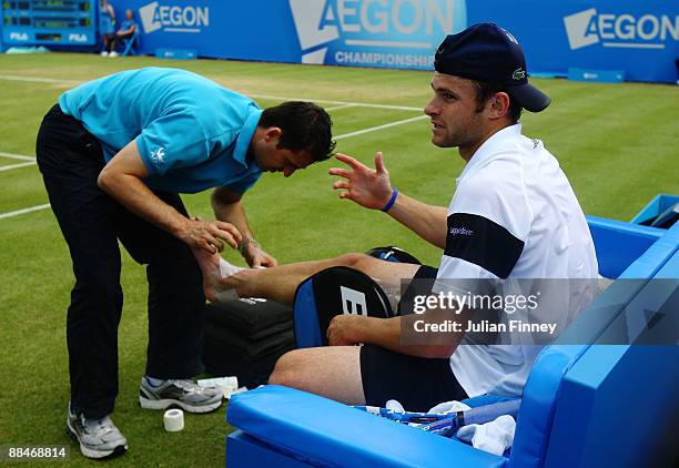 Andy Roddick of USA has his foot strapped before retiring during the men's semi final match against James Blake of USA during Day 6 of the the AEGON...