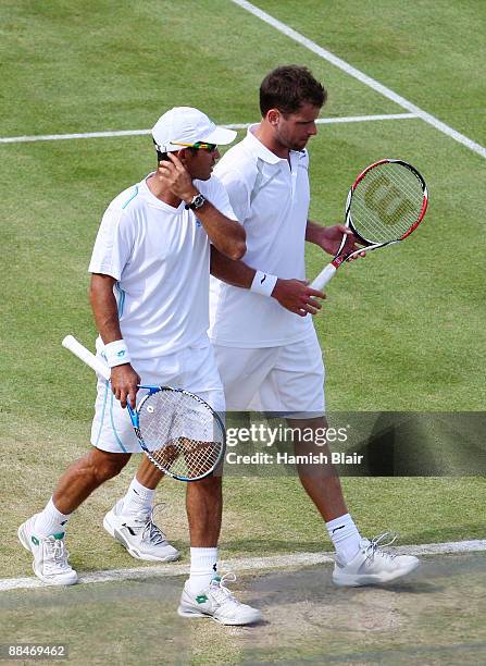 Jeff Coetzee of South Africa talks with Jordan Kerr of Australia during the men's doubles semi final match against Marcelo Melo of Brazil and Andre...