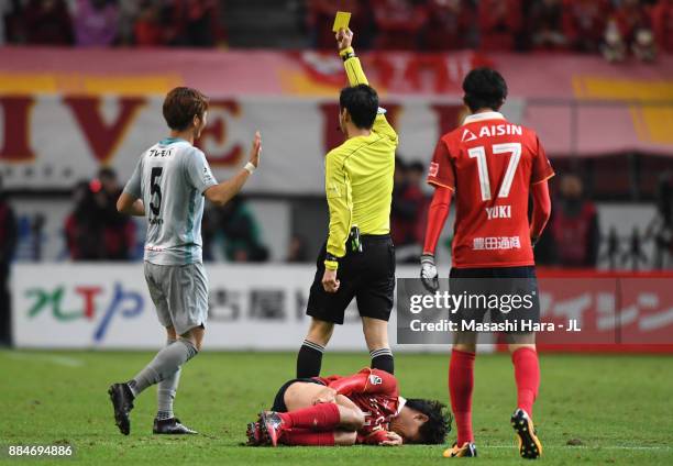 Yuki Saneto of Avispa Fukuoka is shown a yellow card by referee Hiroyuki Kimuraduring the J.League J1 Promotion Play-Off Final between Nagoya Grampus...