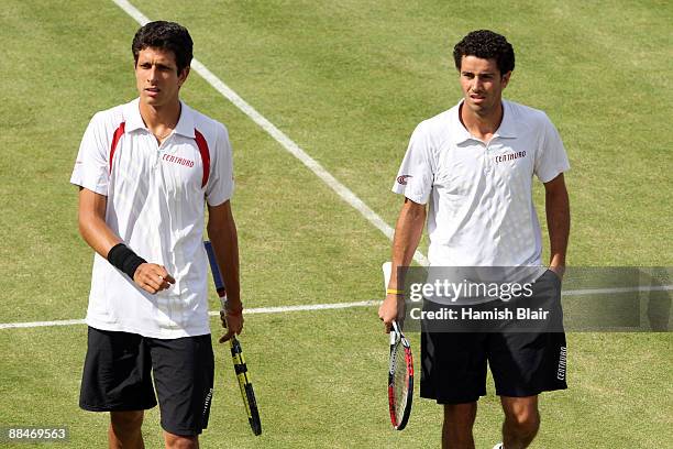 Marcelo Melo of Brazil talks with playing with Andre Sa of Brazil during the men's doubles semi final match against Jeff Coetzee of South Africa and...