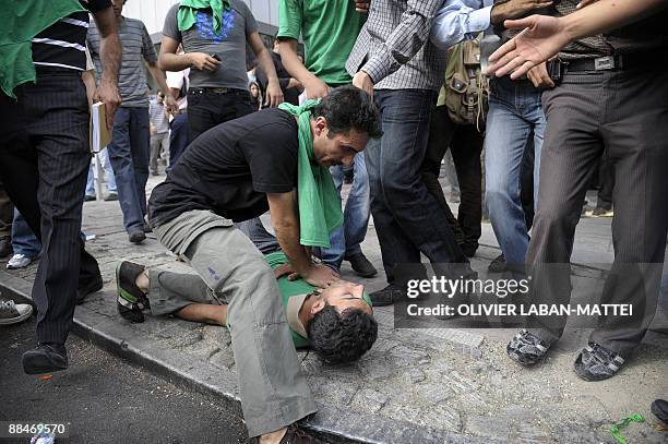 Supporter of defeated Iranian presidential candidate Mir Hossein Mousavi tries to resuscitate an injured fellow protester during riots in Tehran on...
