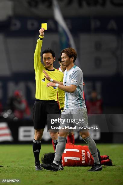 Yuki Saneto of Avispa Fukuoka is shown a yellow card by referee Hiroyuki Kimuraduring the J.League J1 Promotion Play-Off Final between Nagoya Grampus...