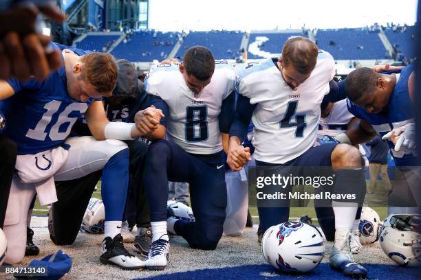 Marcus Mariota and Ryan Succop of the Tennessee Titans pray with members of the Indianapolis Colts after the game at Lucas Oil Stadium on November...