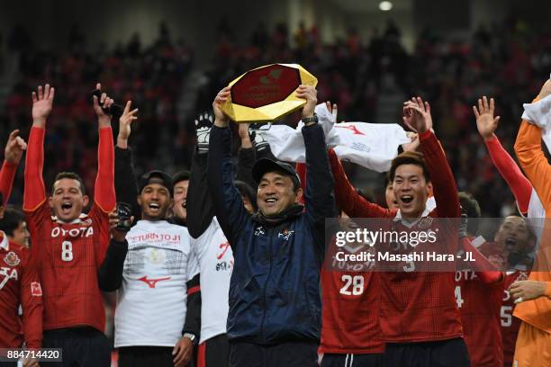 Head coach Yahiro Kazama of Nagoya Grampus lifts the trophy as they celebrate the promotion to the J1 after the J.League J1 Promotion Play-Off Final...