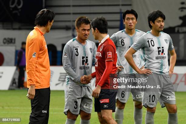 Yuichi Komano of Avispa Fukuoka is consoled by Seigo Narazaki and Keiji Tamada of Nagoya Grampus after the J.League J1 Promotion Play-Off Final...