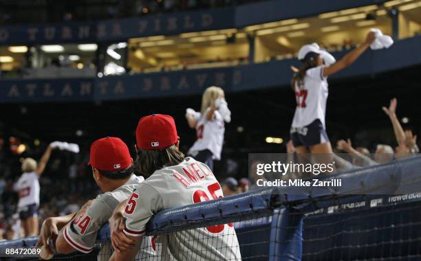 Phillies pitchers Freddy Garcia and Cole Hamels watch the Braves cheerleaders dance on the dugout during the game between the Atlanta Braves and the...