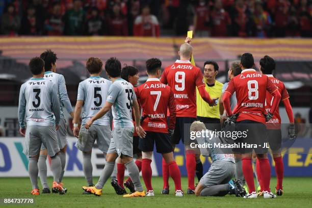 Robin Simovic of Nagoya Grampus is shown a yellow card by referee Hiroyuki Kimura during the J.League J1 Promotion Play-Off Final between Nagoya...