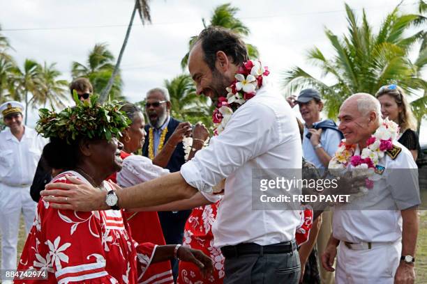 French Prime Minister Edouard Philippe reacts after receiving a flower neklace during a welcoming ceremony at the Tiga chiefdom, on Tiga island, in...