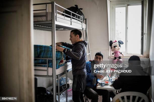 Migrants and part of "freedom team" eat together in a room of at the Orientation and welcoming center where they live in, on November 29, 2017 in...