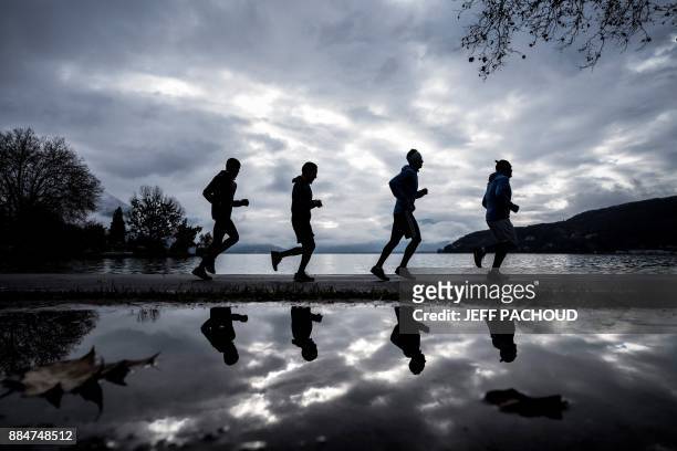 Four members of a trail team called "freedom team" and composed by migrants, take part in a training session on November 29, 2017 in Annecy, to...