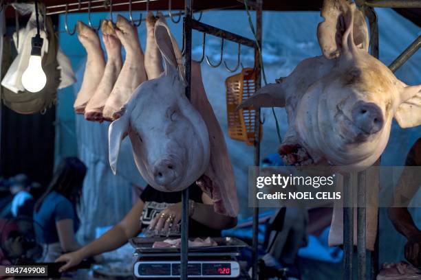 Vendor arranges pork at Divisoria market in Manila on December 3, 2017. / AFP PHOTO / Noel CELIS