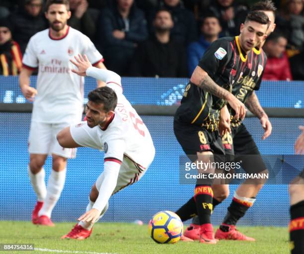 Milan's forward Fernandez Suso falls as fighting for the ball with Benevento's Italian midfielder Danilo Cataldi during the Italian Serie A football...