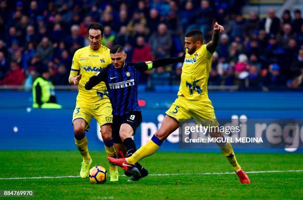 Inter Milan's Captain, Argentinian forward Mauro Icardi vies with Chievo's Italian defender Dario Dainelli and Chievo's Italian defender Alessandro...