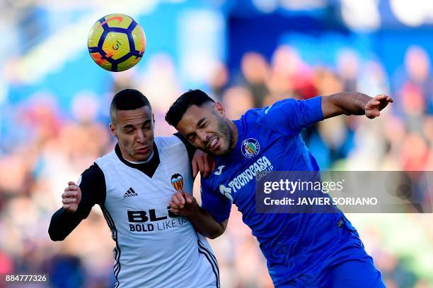 Valencia's Spanish forward Rodri heads the ball with Getafe's Spanish defender Bruno Gonzalez during the Spanish league football match Getafe CF vs...