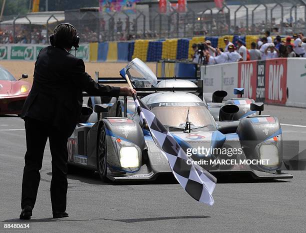 The Peugeot 908 of British driver David Brabham, Austrian Alexander Wurz and Spanish Marc Gene crosses the finish line of the 77th edition of Le Mans...