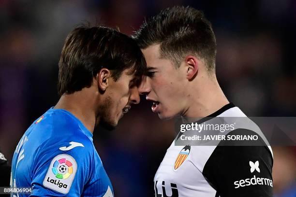 Valencia's Spanish forward Santi Mina Lorenzo and Getafe's Uruguayan defender Damian Suarez argue during the Spanish league football match Getafe CF...