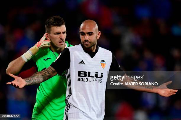 Getafe's Spanish goalkeeper Vicente Guaita reacts behind Valencia's Italian forward Simone Zaza after blocking his shot on goal during the Spanish...