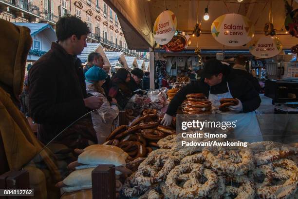 Man buys a bretzel at the Christmas Market in Castello square during the Christmas period on December 3, 2017 in Turin, Italy.