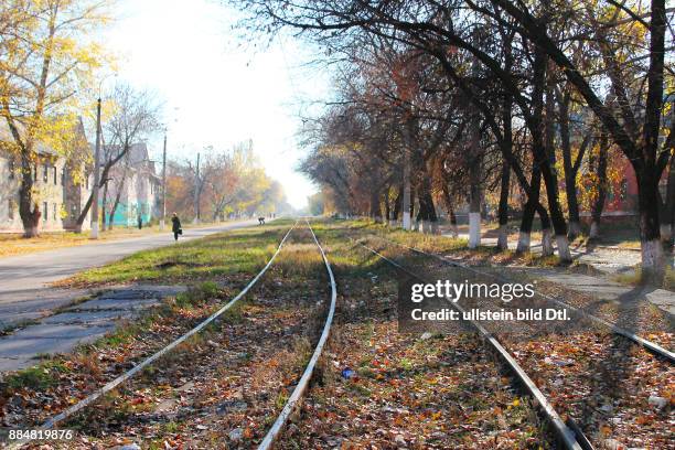Ukraine, das Donezbecken, Kurzform Donbass, Gebiet Donezk, Gorlowka , Siedlung Bairak, ein stiller Vorort, Strasse ohne Strassenverkehr, Gleise der...