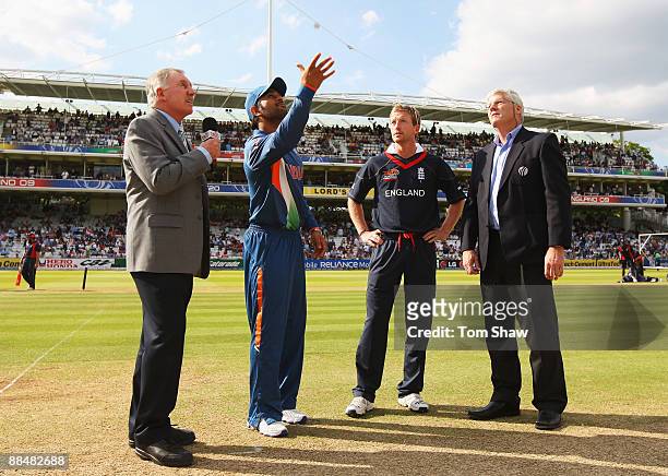 Mahendra Singh Dhoni of India tosses the coin watched by Paul Collingwood of England, match referee Alan Hurst and commentator Ian Chappell during...