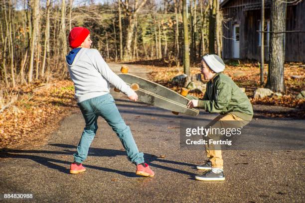 brothers fighting over a skateboard - brother fight stock pictures, royalty-free photos & images