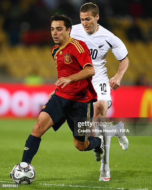 Xavi of Spain is chased by Chris Killen of New Zealand during the FIFA Confederations Cup group match between New Zealand and Spain at the Royal...