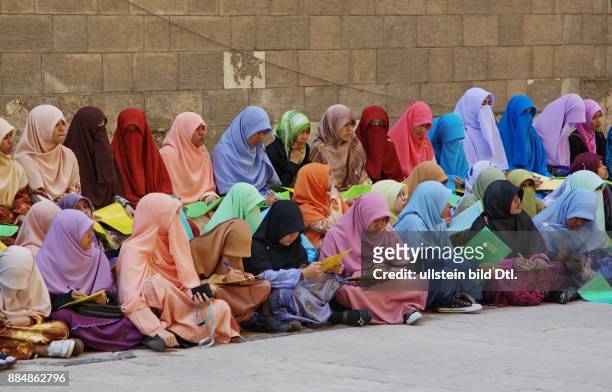 Schülerinnen einer indonesischen Koran-Schule in bunten Kleidern vor der Sultan-Hasan-Moschee