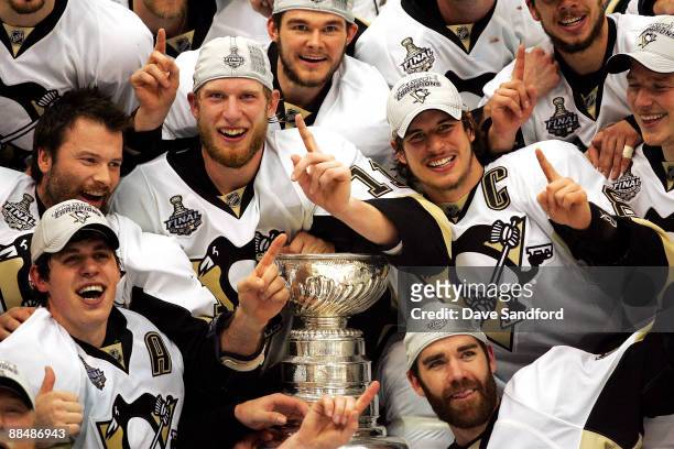 Sidney Crosby of the Pittsburgh Penguins celebrates with teammates Jordan Staal, Evgeni Malkin and Pascal Dupuis as they pose for a team photo...