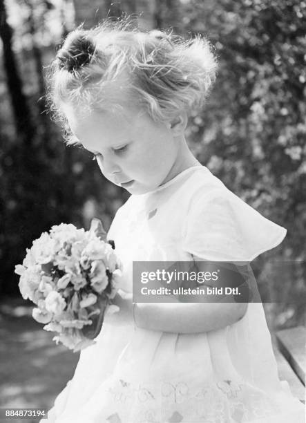 Kleines Mädchen im weissen Kleid, mit Blumenstrauss