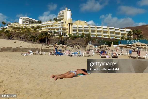 Sonnenbaden am Strand - Hintergrund das Hotel RIU Palace - gesehen in Jandia auf Fuerteventura-Süd