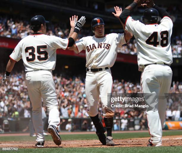 Nate Schierholtz of the San Francisco Giants is safe at home with an inside the park home run against the Oakland Athletics and celebrates with his...