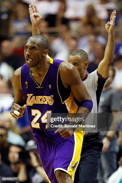 Kobe Bryant of the Los Angeles Lakers reacts after making a three-pointer as referee Dan Crawford holds up his arms in the second half against the...