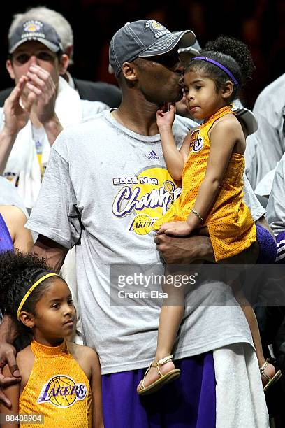 Kobe Bryant of the Los Angeles Lakers kisses his daughter, Gianna, as daughter Natalia stands by his side after the Lakers defeated the Orlando Magic...