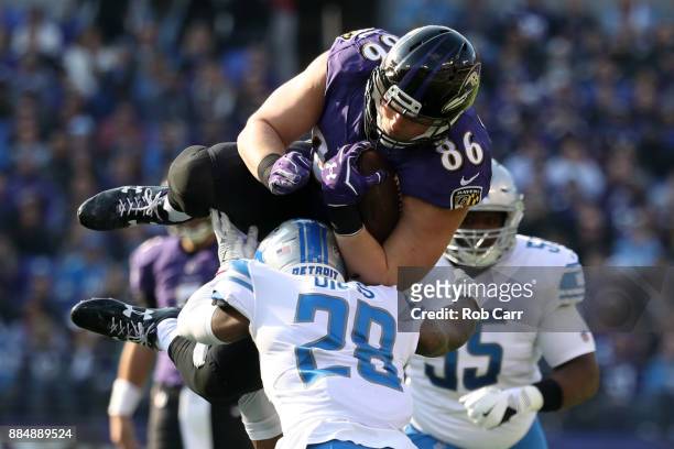 Tight End Nick Boyle of the Baltimore Ravens is tackled as he carries the ball by cornerback Quandre Diggs of the Detroit Lions in the first quarter...