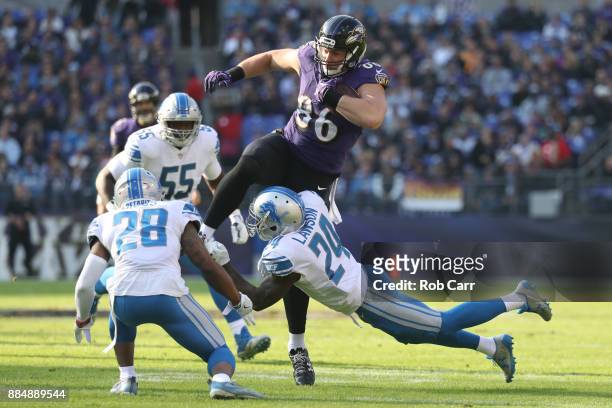 Tight End Nick Boyle of the Baltimore Ravens leaps as he carries the ball over cornerback Nevin Lawson of the Detroit Lions in the first quarter...