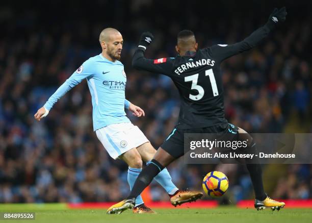 David Silva of Manchester City passes the ball past Edimilson Fernandes of West Ham United during the Premier League match between Manchester City...