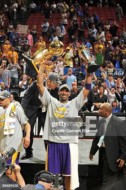 Kobe Bryant of the Los Angeles Lakers hoists the Larry O' Brien and Bill Russell MVP trophy after defeating the Orlando Magic in Game Five of the...
