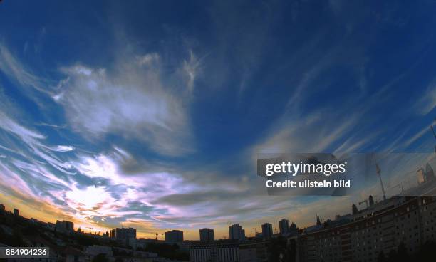 Zerkluefteter Wolken-Himmel uber Ost-West Skyline Berlins.