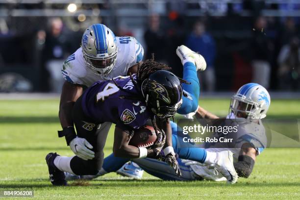 Running Back Alex Collins of the Baltimore Ravens is tackled by linebacker Jarrad Davis of the Detroit Lions in the second quarter at M&T Bank...