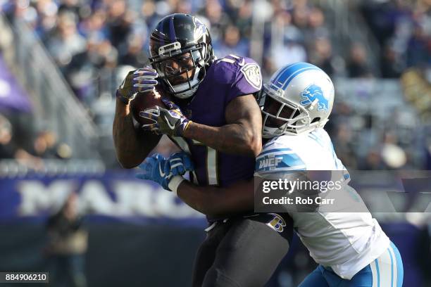 Wide Receiver Mike Wallace of the Baltimore Ravens catches a pass in the first quarter as he is tackled by defensive back D.J. Hayden of the Detroit...