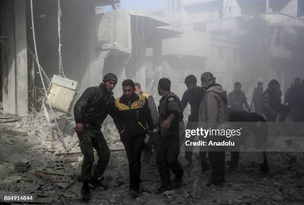 Syrian rescue teams carry a wounded person following the Assad regime's air strikes over residential areas in the de-escalation zone in the Eastern...