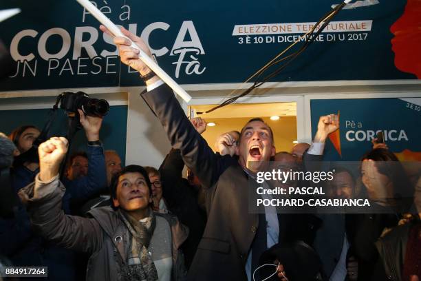 Candidate for the Pe a Corsica nationalist party for Corsican regional elections Gilles Simeoni waves a flag as he celebrates with supporters in...