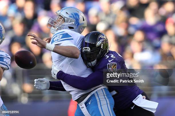 Free Safety Eric Weddle of the Baltimore Ravens forces a fumble as he tackles quarterback Matthew Stafford of the Detroit Lions at M&T Bank Stadium...