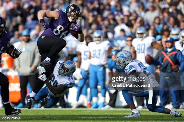 Tight End Nick Boyle of the Baltimore Ravens leaps over cornerback Nevin Lawson of the Detroit Lions in the first quarter at M&T Bank Stadium on...