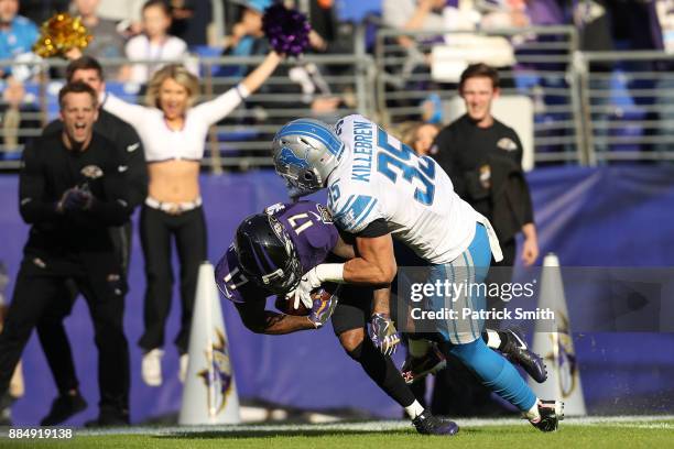 Wide Receiver Mike Wallace of the Baltimore Ravens is tackled by strong safety Miles Killebrew of the Detroit Lions in the second quarter at M&T Bank...