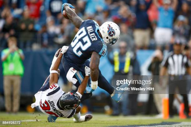 Delanie Walker of the Tennessee Titans runs into the endzone for a touchdown defended by Kevin Johnson of the Houston Texans during the second half...