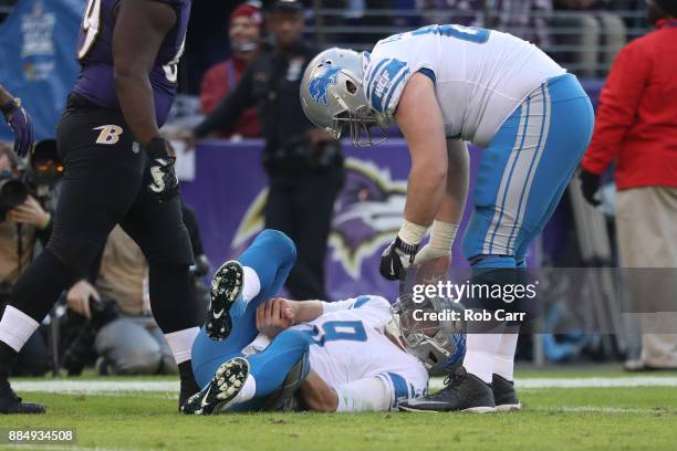 Quarterback Matthew Stafford of the Detroit Lions grabs his hand after being tackled in the fourth quarter against the Baltimore Ravens at M&T Bank...
