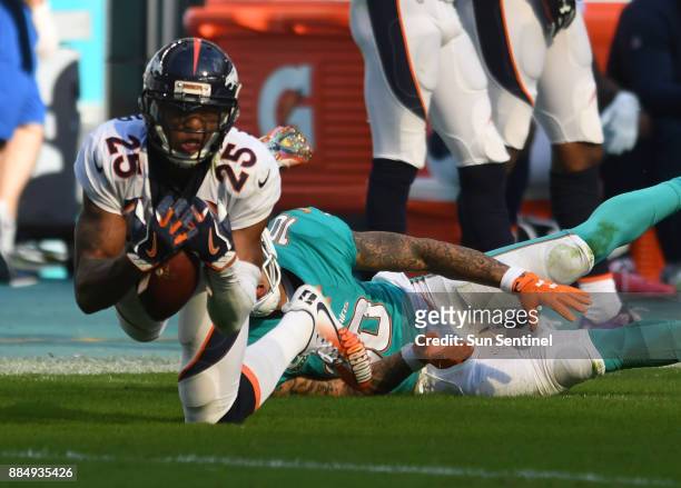 Denver Broncos cornerback Chris Harris intercepts a pass intended for Miami Dolphins wide receiver Kenny Stills in the second quarter on Sunday, Dec....